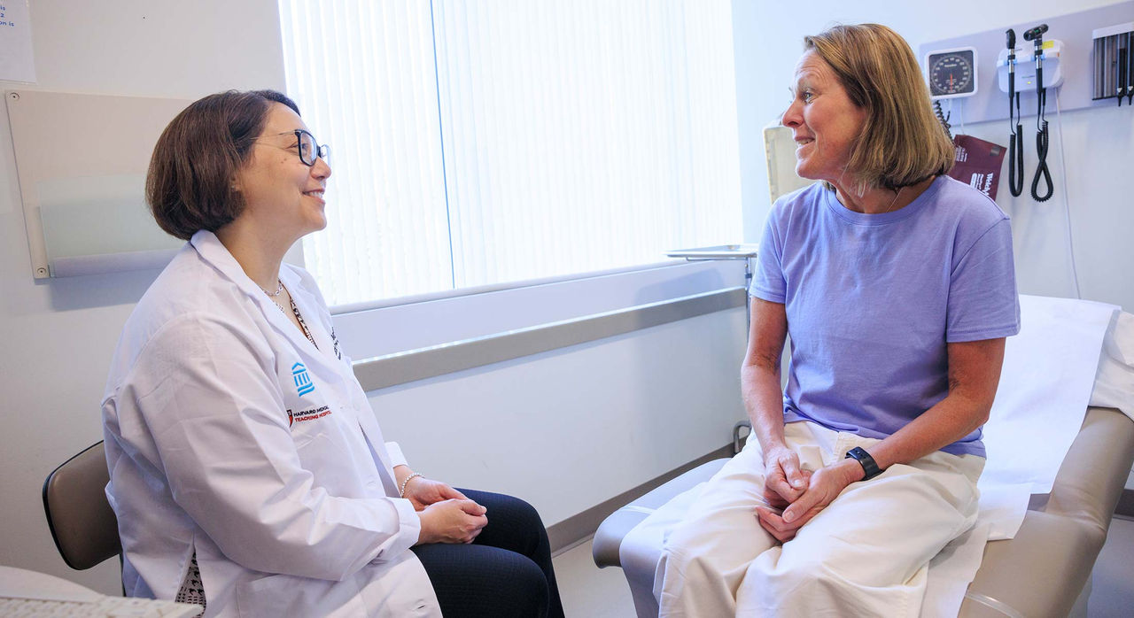 Lecia Sequist, MD, MPH, a medical oncologist, consults with a female patient in a medical examination room.