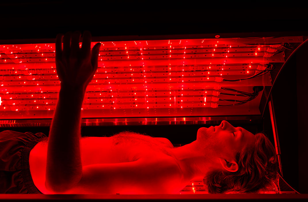 man laying in photobiomodulation therapy bed